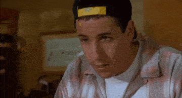 a man wearing a baseball cap and a plaid shirt looks at something