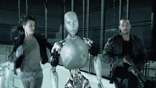 a man holding a gun stands next to a woman and a silver robot