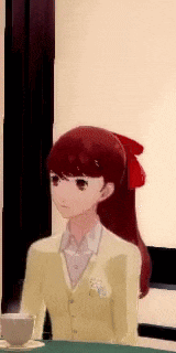 a girl in a yellow jacket is sitting at a table with a cup of coffee .