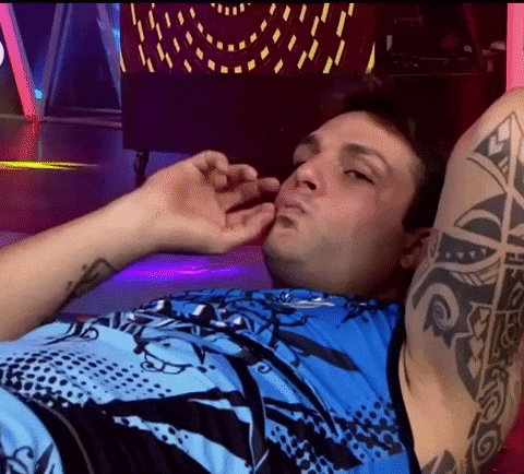 a man with a tattoo on his arm is laying down with his eyes closed