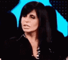 a woman with long black hair is smiling and wearing a black jacket .