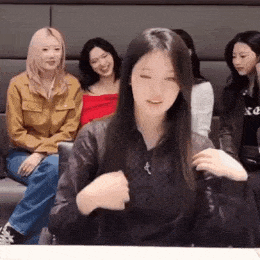 a group of young women are sitting on a couch and laughing .