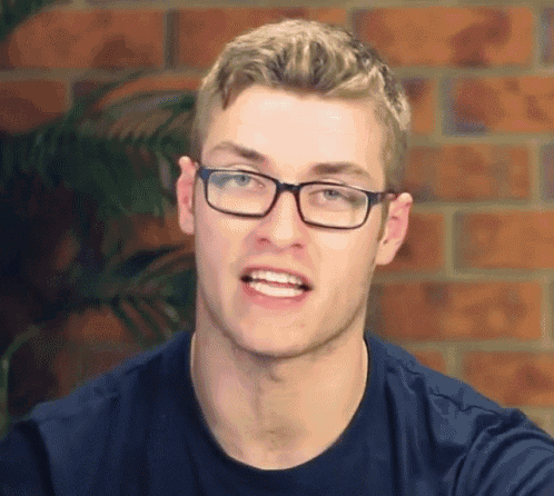 a man wearing glasses and a blue shirt is making a face