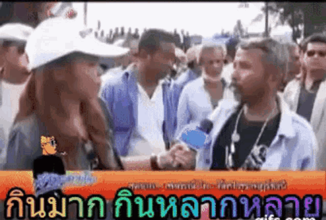 a man and woman are shaking hands in front of a crowd of people .