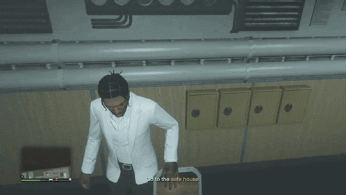 a man in a white suit is standing next to a box that says " go to the safe house "