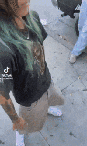 a woman with green hair is wearing a black shirt that says tiktok