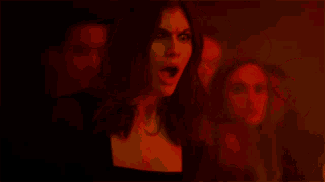 a woman in a dark room with a red light on her face