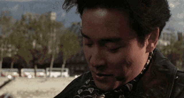 a man with a scarf around his neck looks down
