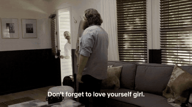 a man standing in a living room with the words " don t forget to love yourself girl " below him