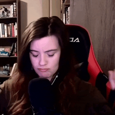 a woman sitting in a red gaming chair with the letter a on the back