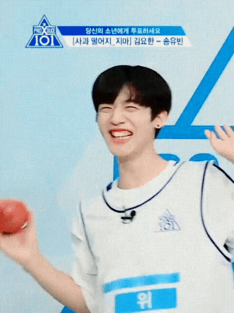 a young man is smiling and pointing at something in front of a sign that says ro