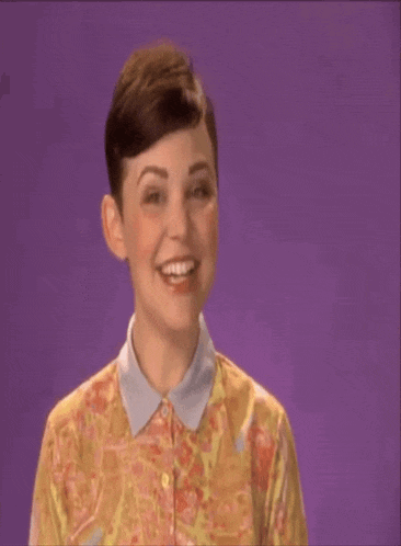 a woman in a floral shirt says shana tova on a purple background