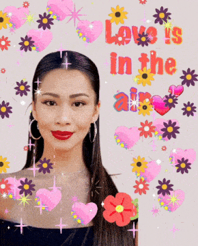 a woman is surrounded by flowers and hearts with the words love is in the air above her