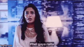 a woman in a white dress is standing in front of a television screen with a caption that reads phel gaya raita .