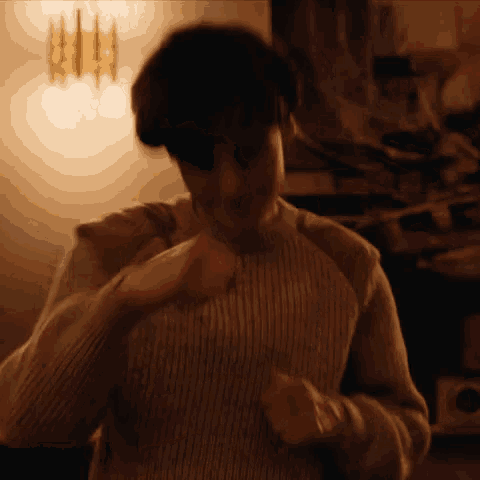 a man in a striped sweater is dancing in a room .