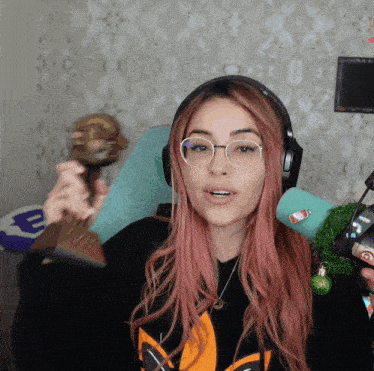 a woman with pink hair wearing glasses and headphones