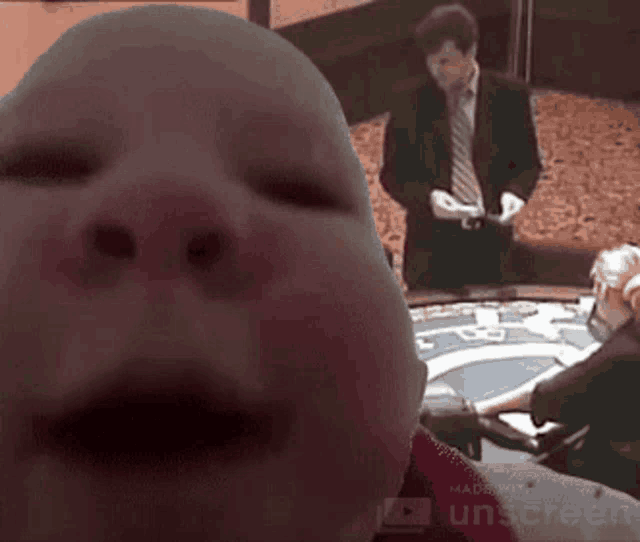 a man in a suit and tie stands behind a baby