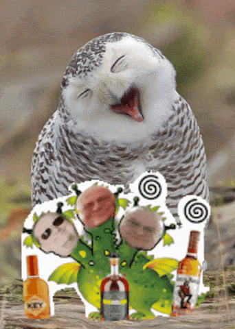 a bottle of key sits on a table next to a owl