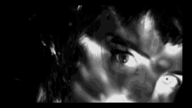 a close up of a woman 's face in a black and white photo