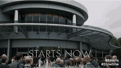 a crowd of people are gathered in front of a building that says " starts now "