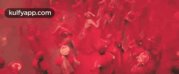 a group of people are standing in a room covered in red paint .