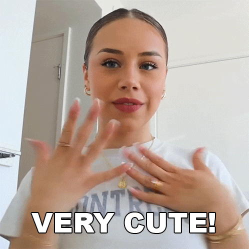 a woman in a white shirt says very cute with her hands on her chest