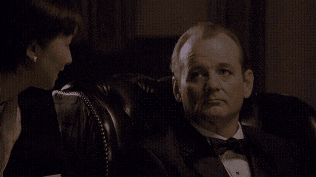 a man in a tuxedo sitting next to a woman