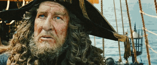 a man with long hair and a beard wearing a hat