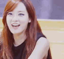 a woman with red hair is smiling and wearing a black shirt