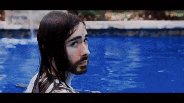 a man with long hair and a beard is in a swimming pool