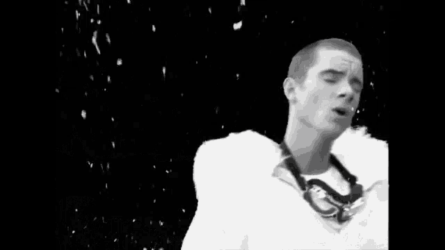 a black and white photo of a man wearing a white jacket with a fur collar .