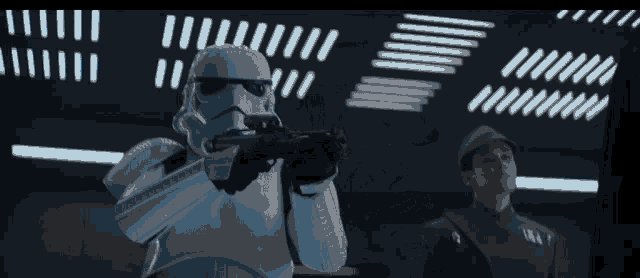 a storm trooper is holding a gun in front of a man in a black uniform