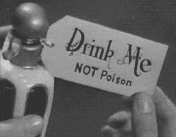 a person is holding a drink me not poison tag