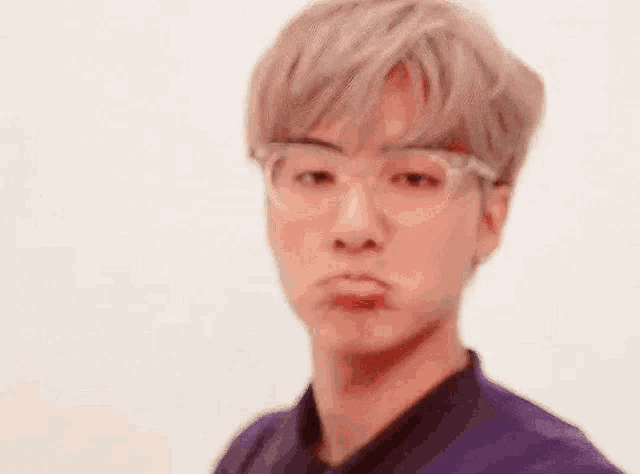 a close up of a man wearing glasses making a funny face .