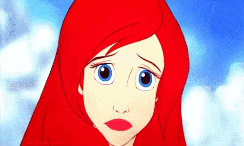 a close up of a cartoon character 's face with red hair and blue eyes .