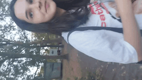 a girl wearing a white shirt that says " beth " on it