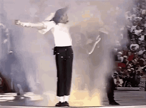 a man in a white shirt and black pants is dancing on a stage .
