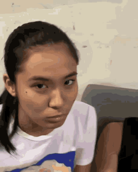 a young girl is making a funny face while sitting on a couch