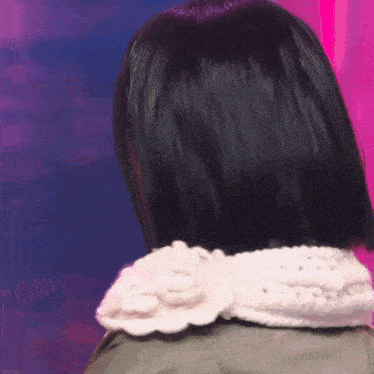 a close up of a woman 's back with a white flower on her collar .