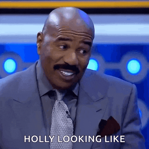 a bald man in a suit and tie is smiling and saying holly looking like