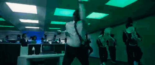 a man in a suit and tie is dancing in a dark room .