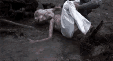 a person is laying on the ground with a white cloth on their back .
