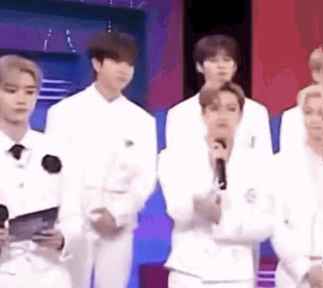 a group of people in white suits are standing next to each other .
