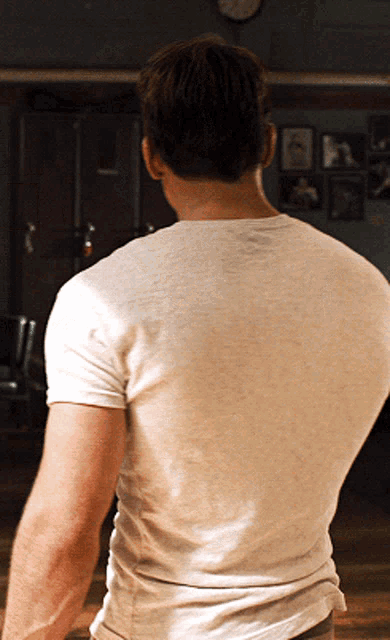 the back of a man wearing a white t-shirt is shown