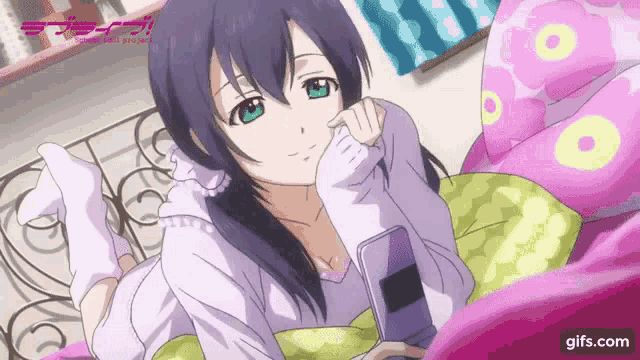 a girl laying on a bed looking at a cell phone with a gifs.com logo in the background