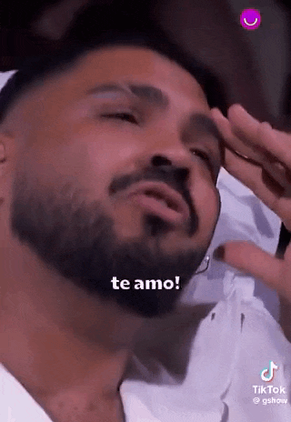 a man with a beard is holding his hand to his forehead and says `` te amo '' .