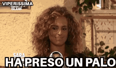 a woman with curly hair is smiling with the words ha preso un palo written on the bottom .