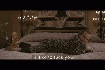 a man is laying on a bed with the words `` i 'd like to fuck you '' written on the bottom .