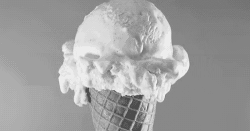 a black and white photo of a waffle cone with ice cream on it .