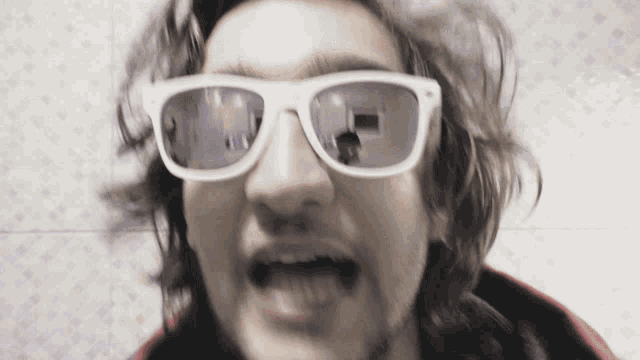 a close up of a person wearing sunglasses with a reflection